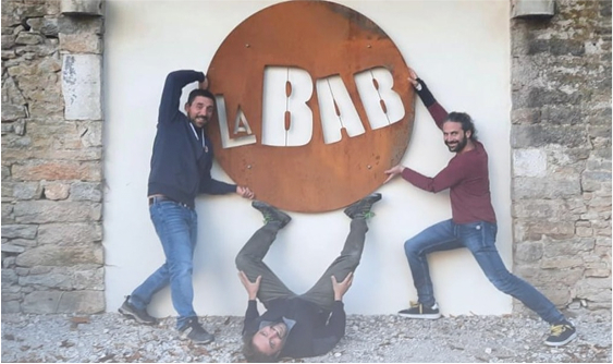 Devanture de la brasserie la bab avec le logo et trois personnes autour